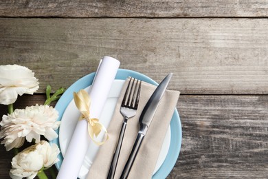 Photo of Stylish table setting with cutlery and flowers on wooden background, flat lay. Space for text
