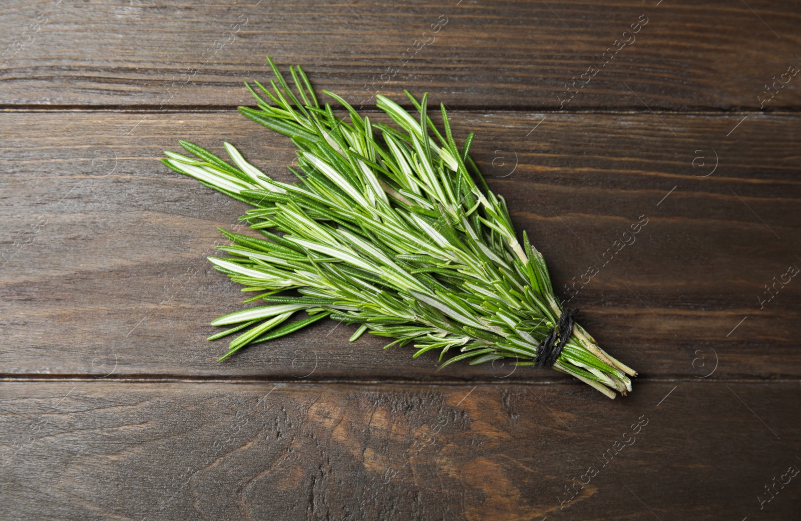 Photo of Bunch of fresh rosemary on wooden table, top view