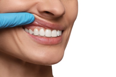 Doctor examining woman's gums on white background, closeup