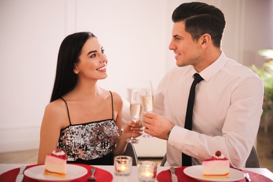 Happy couple having romantic dinner on Valentine's day indoors