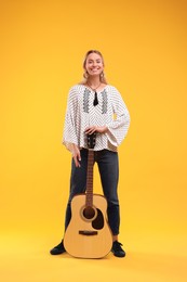 Photo of Happy hippie woman with guitar on yellow background