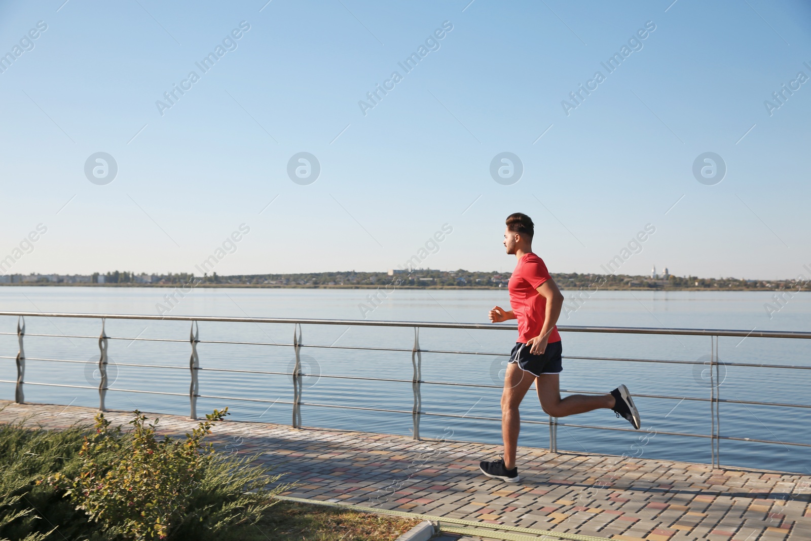 Photo of Sporty man running outdoors on sunny morning