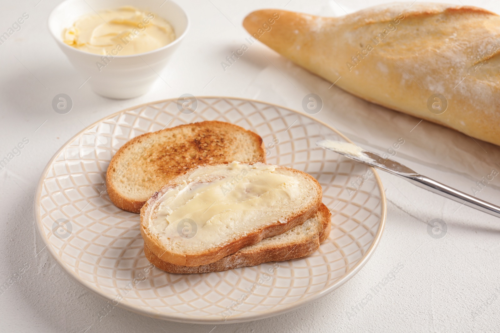 Photo of Tasty bread with butter for breakfast on plate