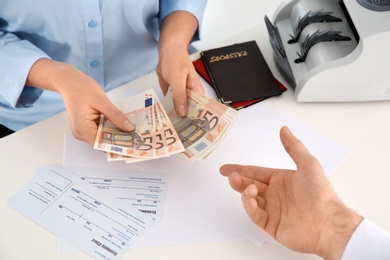 Man receiving money from teller at cash department, closeup