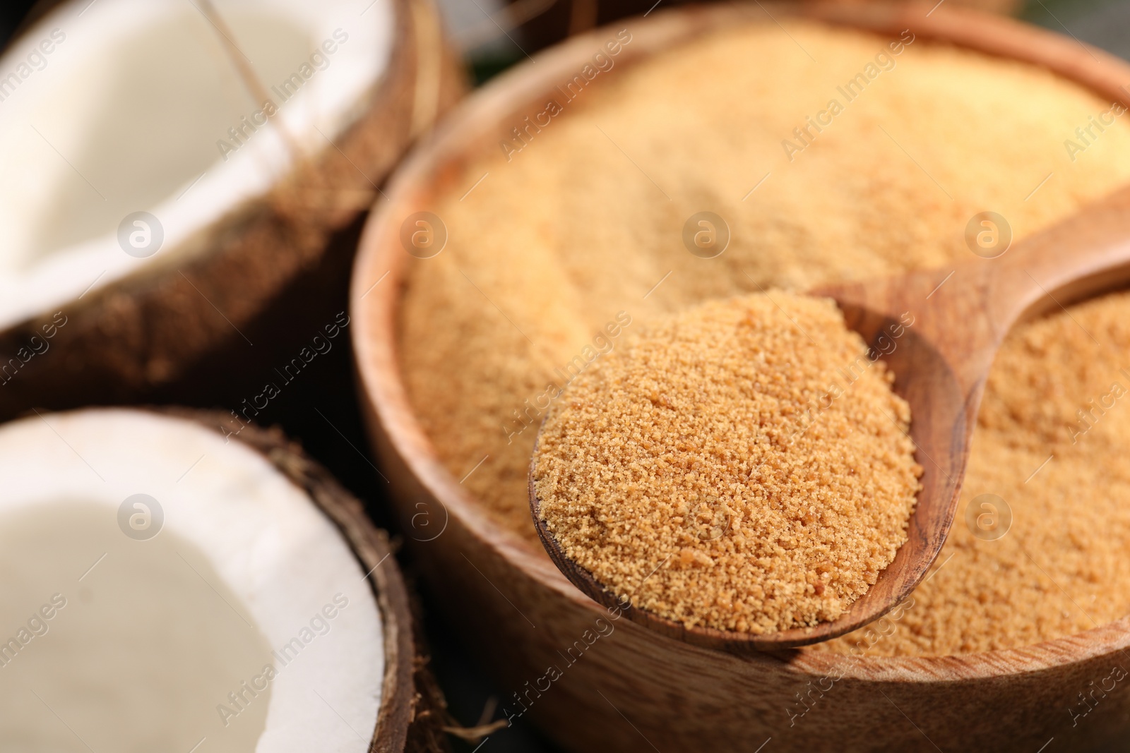 Photo of Spoon with coconut sugar, bowl and fruits, closeup