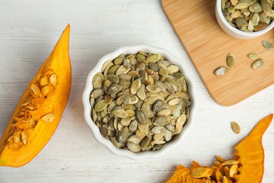 Photo of Flat lay composition with raw pumpkin seeds on white wooden table