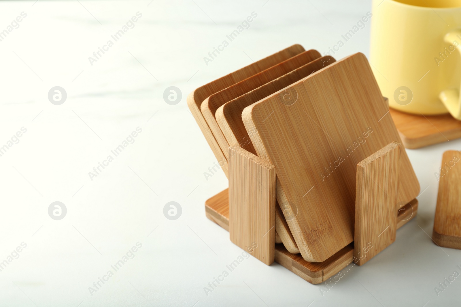 Photo of Stylish wooden cup coasters on white table, space for text