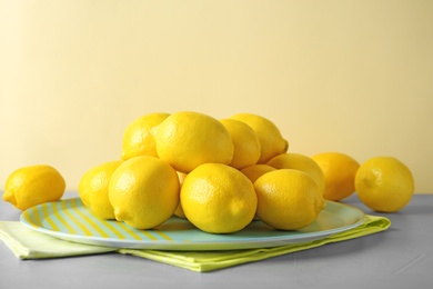 Plate with fresh ripe lemons on table