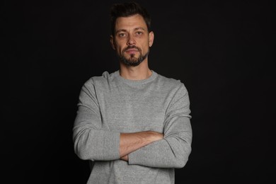 Photo of Portrait of serious man on black background