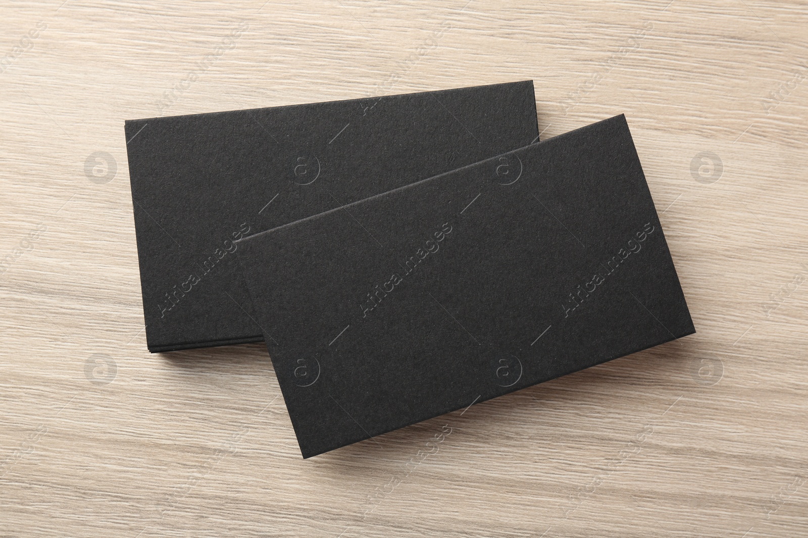 Photo of Blank black business cards on wooden table, top view. Mockup for design