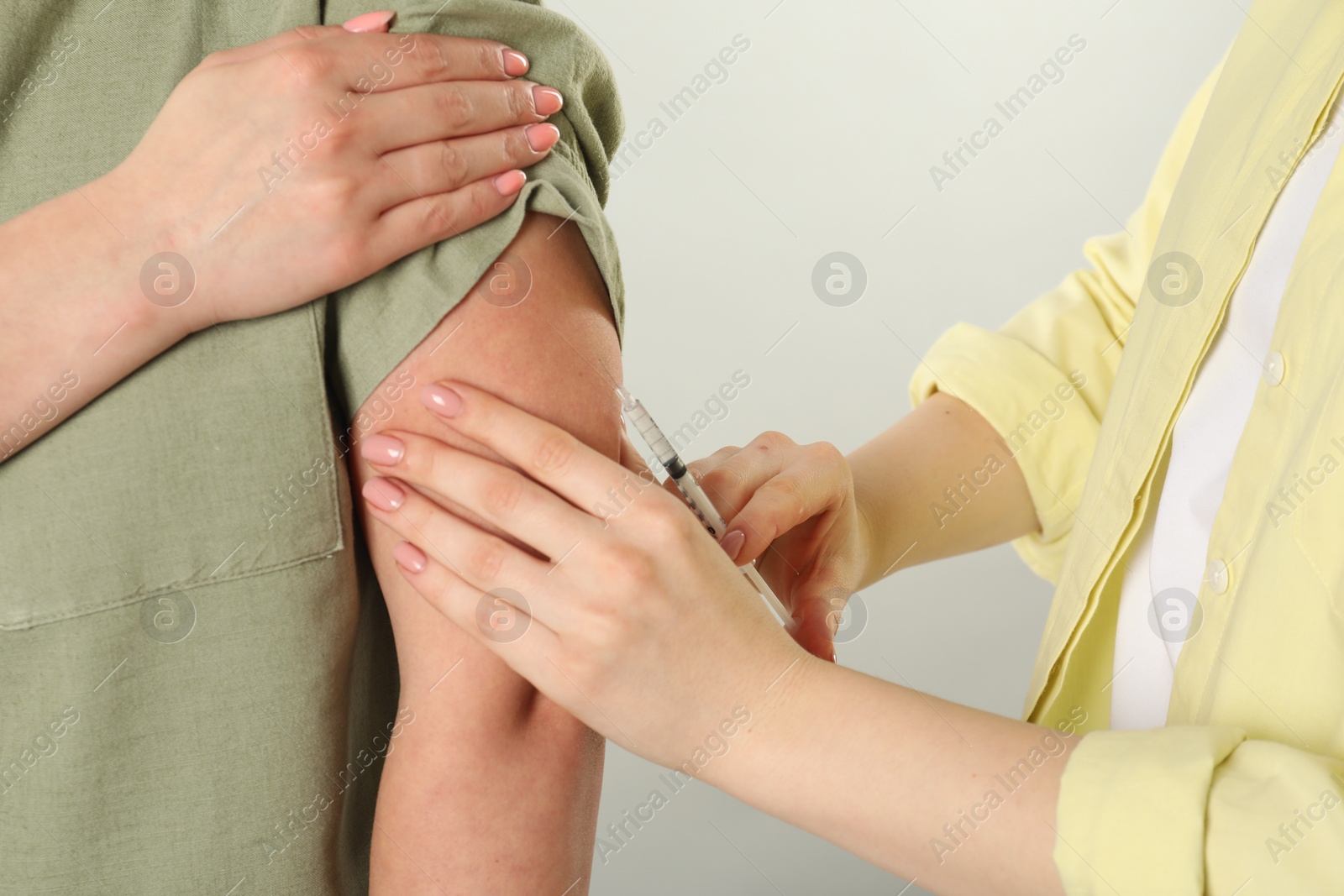 Photo of Diabetes. Woman getting insulin injection on grey background, closeup