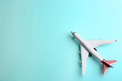 Photo of Toy airplane on light blue background, top view. Space for text