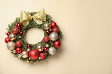 Beautiful Christmas wreath with festive decor on beige background. Space for text