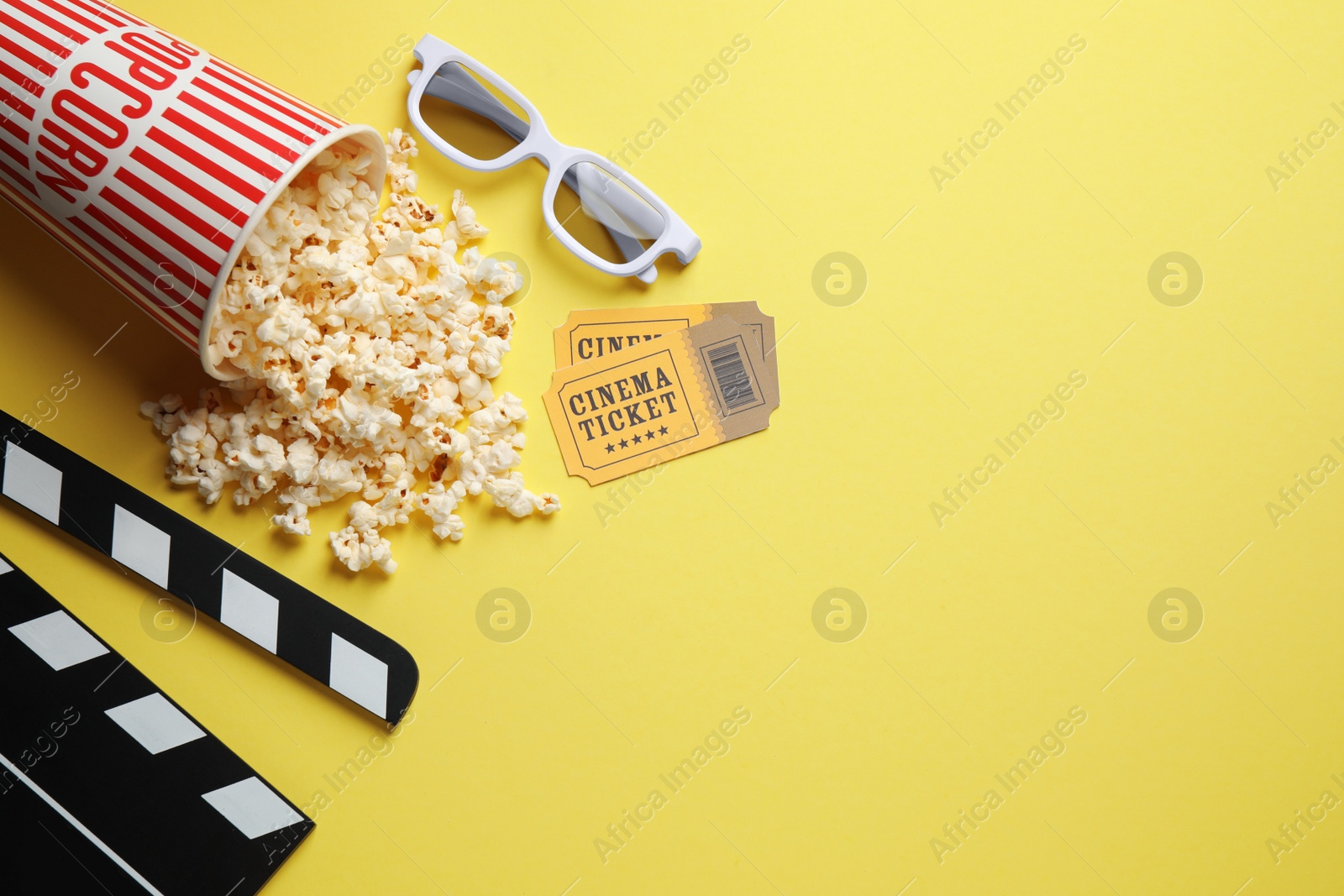 Photo of Flat lay composition with delicious popcorn on yellow background. Space for text