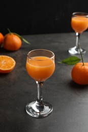 Delicious tangerine liqueur and fresh fruits on grey table