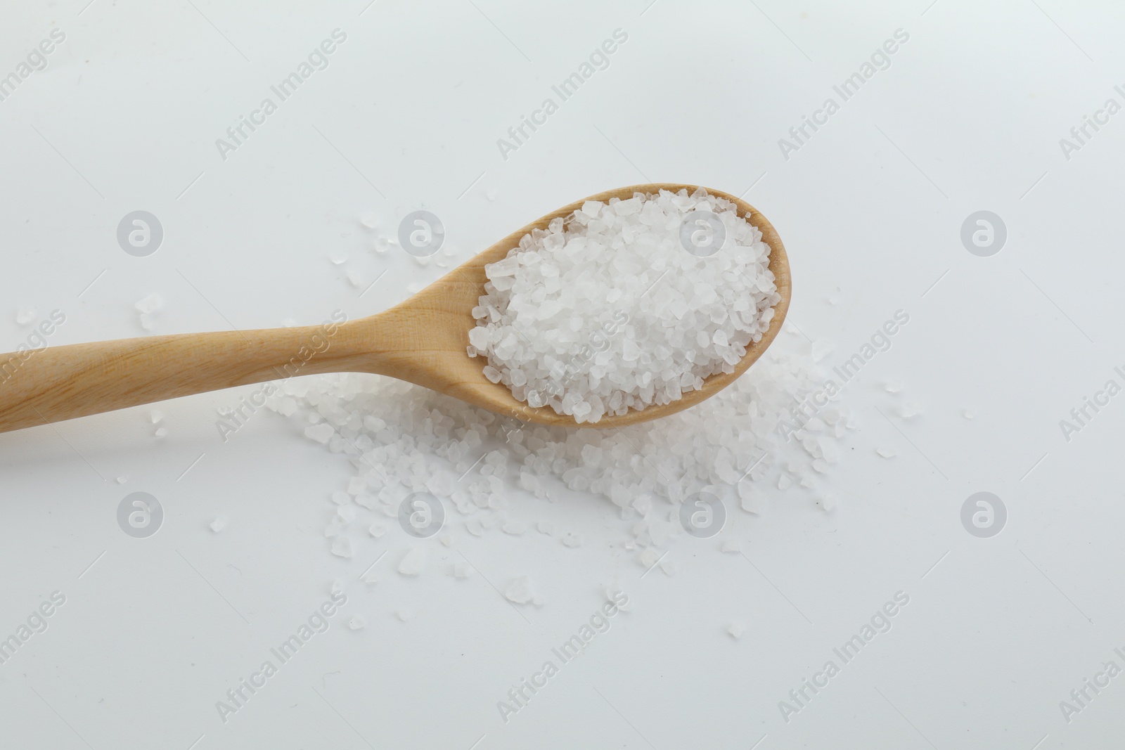 Photo of Natural salt in wooden spoon isolated on white