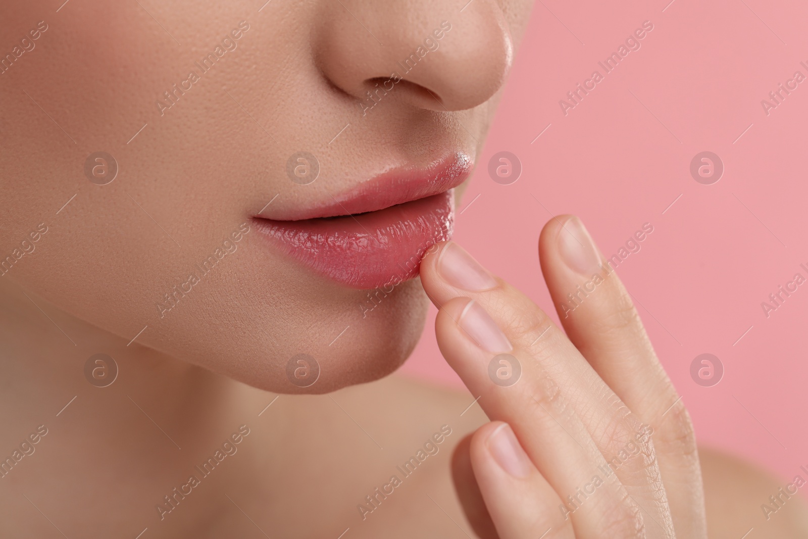 Photo of Young woman with beautiful full lips on pink background, closeup