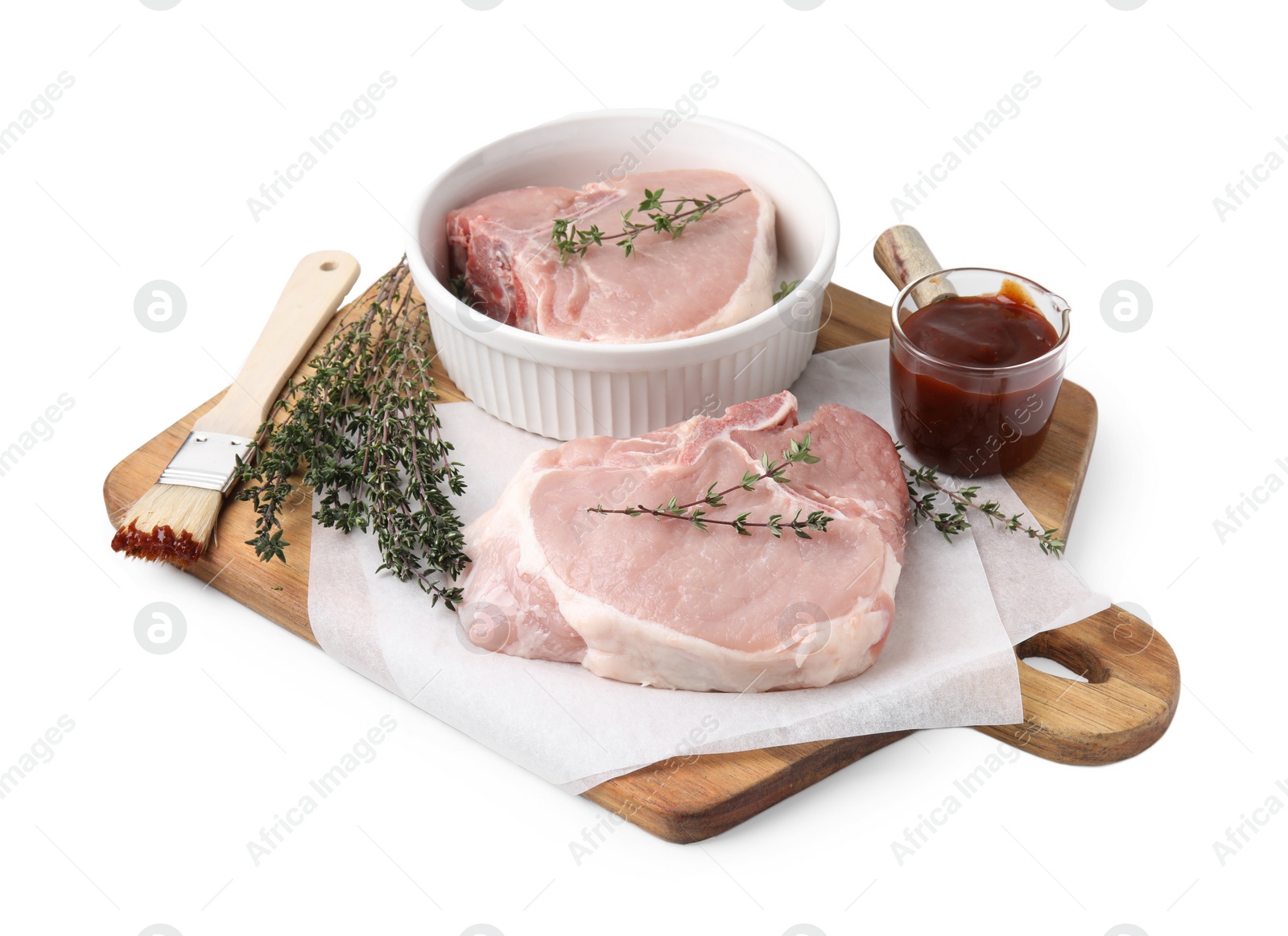 Photo of Board with raw meat, thyme, basting brush and marinade isolated on white