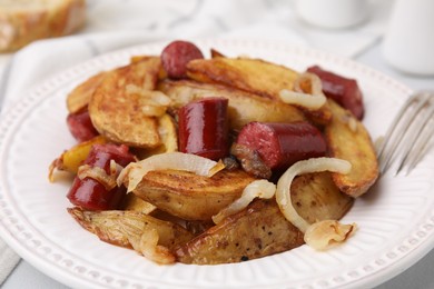 Photo of Delicious baked potato with thin dry smoked sausages and onion on table, closeup