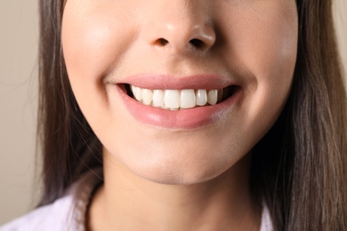 Photo of Young woman with healthy teeth on color background, closeup