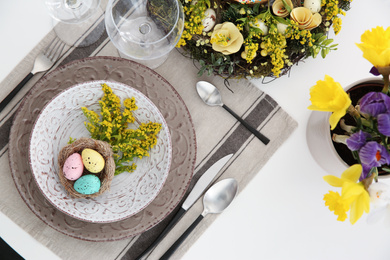 Photo of Festive Easter table setting with beautiful floral decor and eggs, flat lay