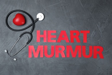 Text Heart Murmur with stethoscope on grey background, flat lay