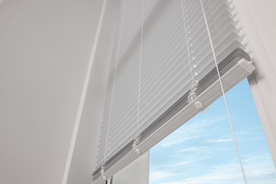 Stylish window with horizontal blinds in room, low angle view