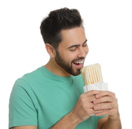 Young man eating tasty shawarma isolated on white