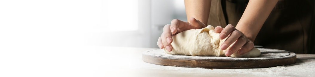 Baker kneading dough at table, closeup. Banner design with space for text