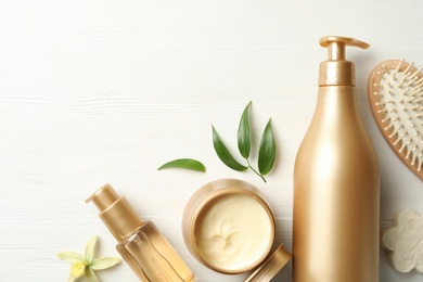 Photo of Flat lay composition with hair cosmetic products on white wooden table
