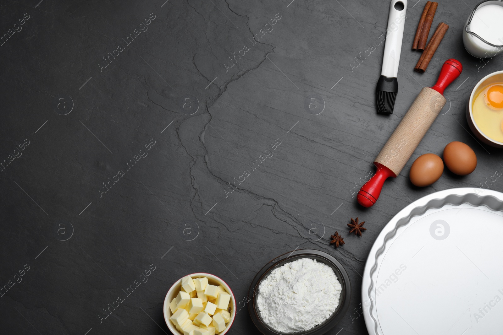 Photo of Cooking utensils and ingredients on black table, flat lay. Space for text