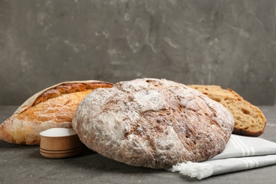 Photo of Different kinds of fresh bread on grey table