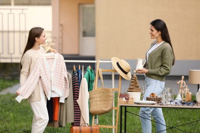 Young women shopping in yard. Garage sale