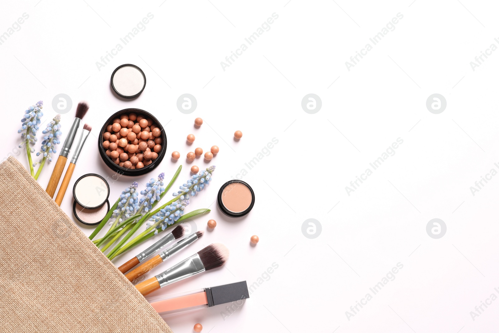 Photo of Makeup products and cosmetic bag on white background, top view
