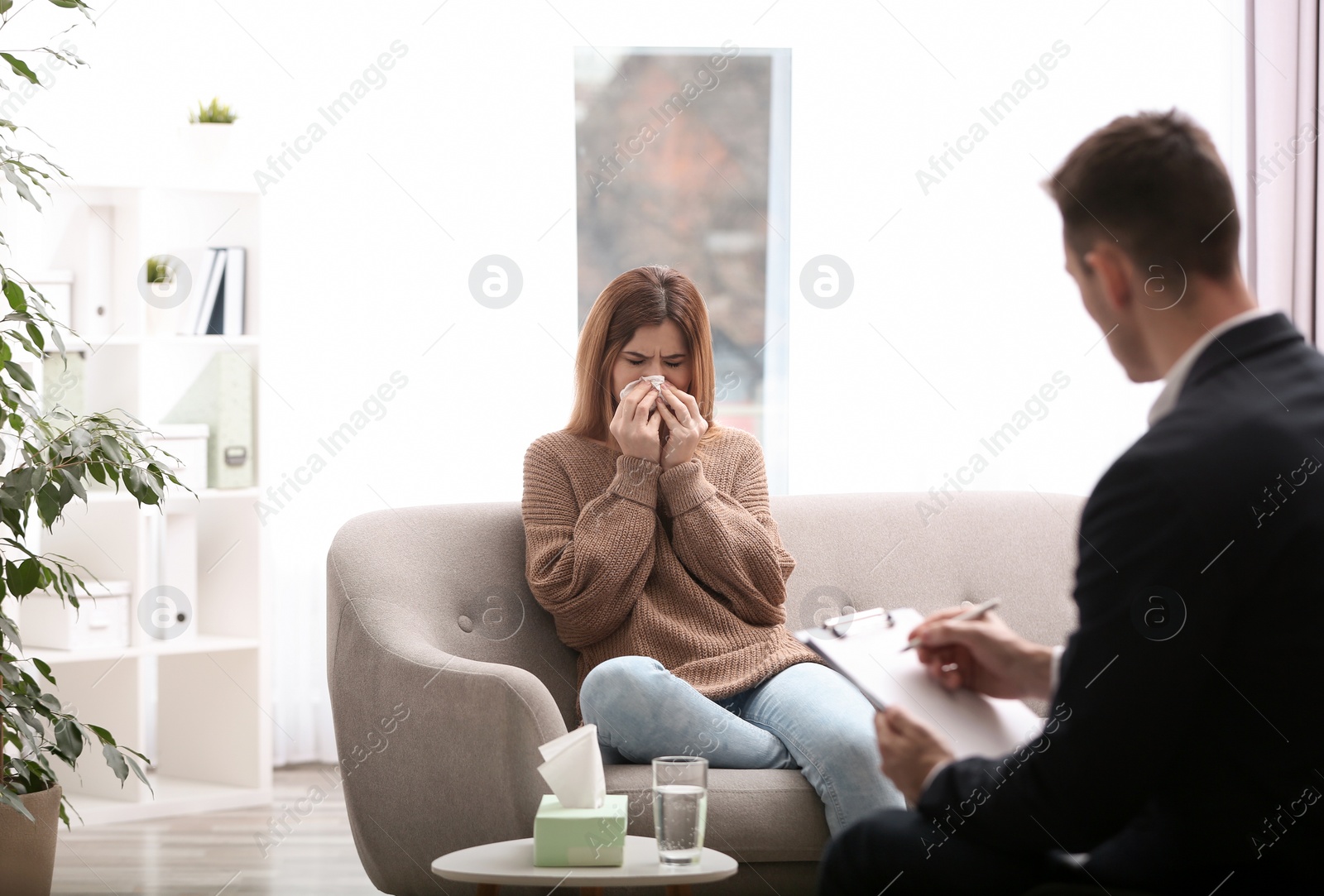 Photo of Psychotherapist working with woman in light office