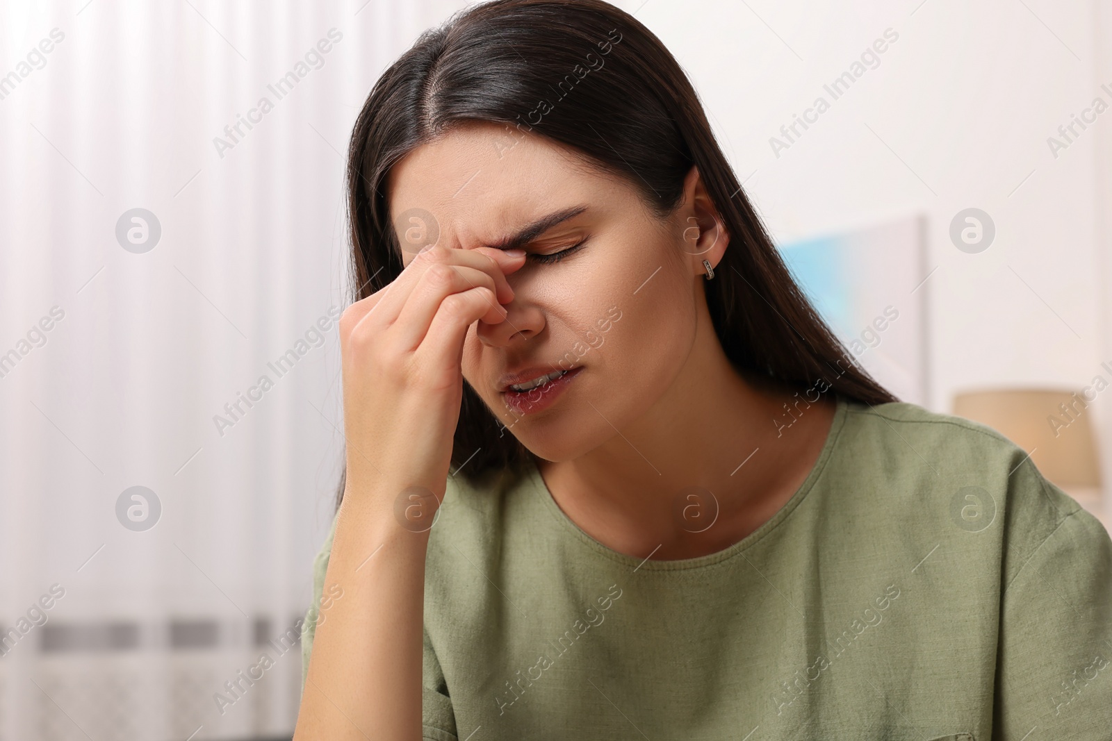 Photo of Sad woman suffering from headache at home