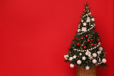 Photo of Christmas tree on red background, space for text