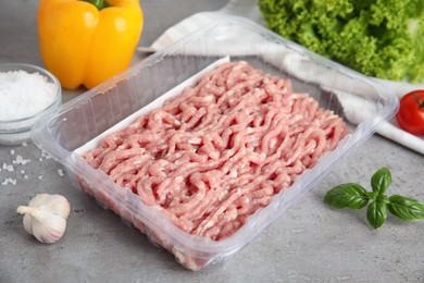 Raw chicken minced meat and ingredients on grey table