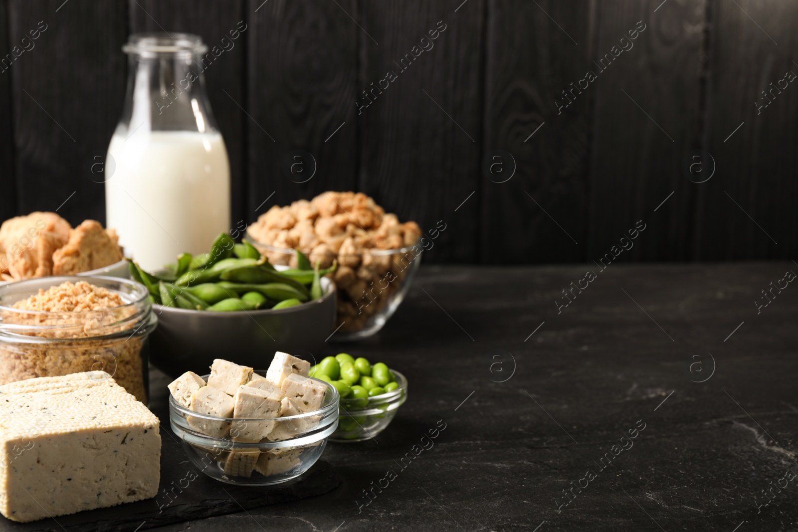 Photo of Different organic soy products on black table. Space for text