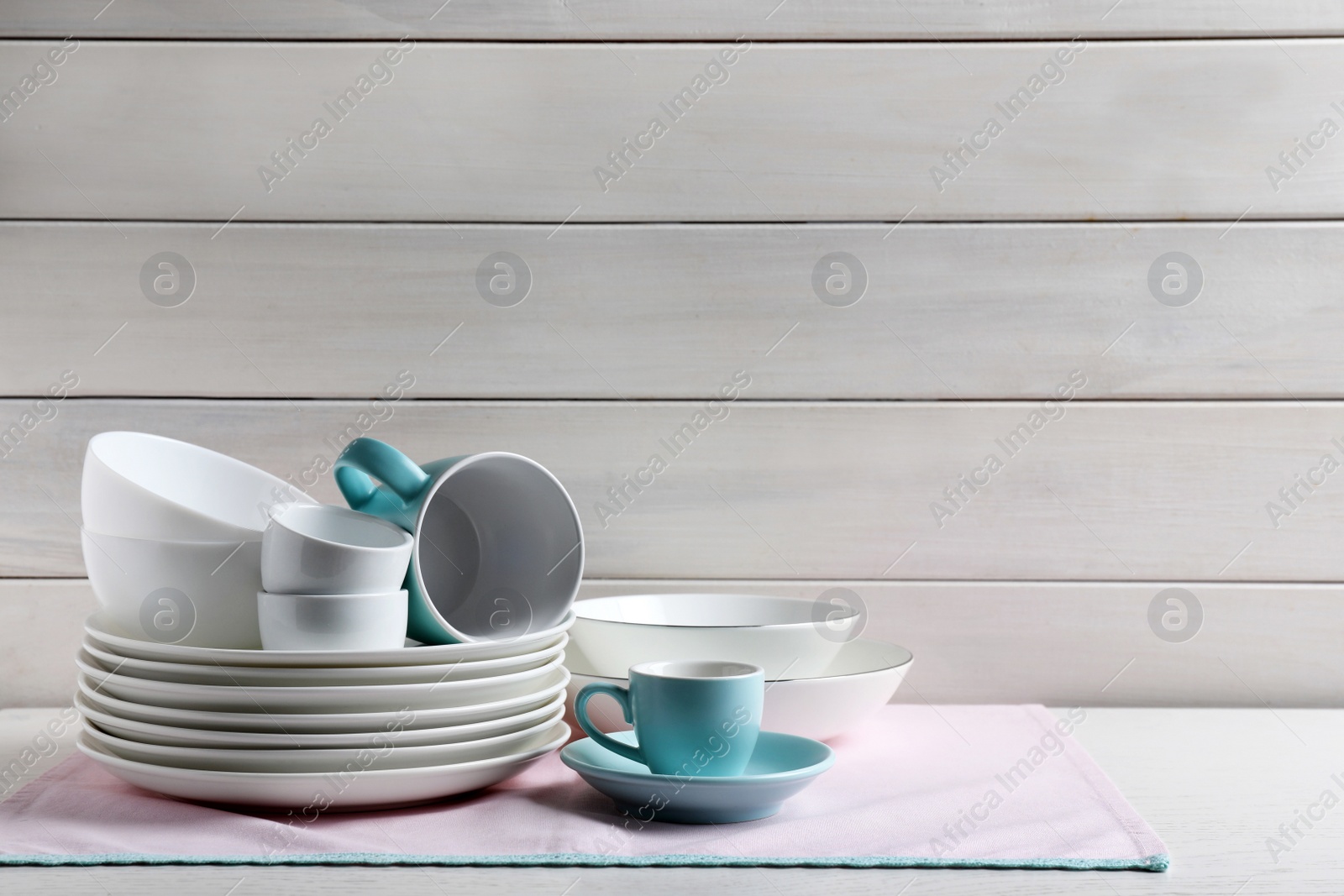 Photo of Set of clean dishware on white table, space for text