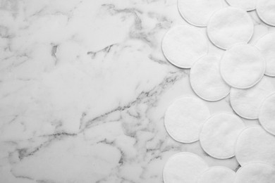 Photo of Many clean cotton pads on white marble table, flat lay. Space for text