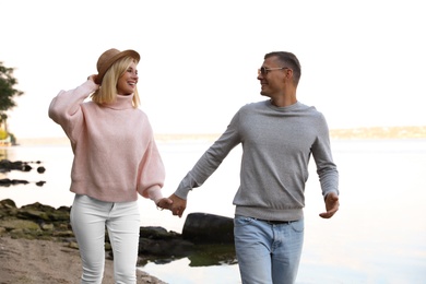 Happy couple in stylish sweaters on beach