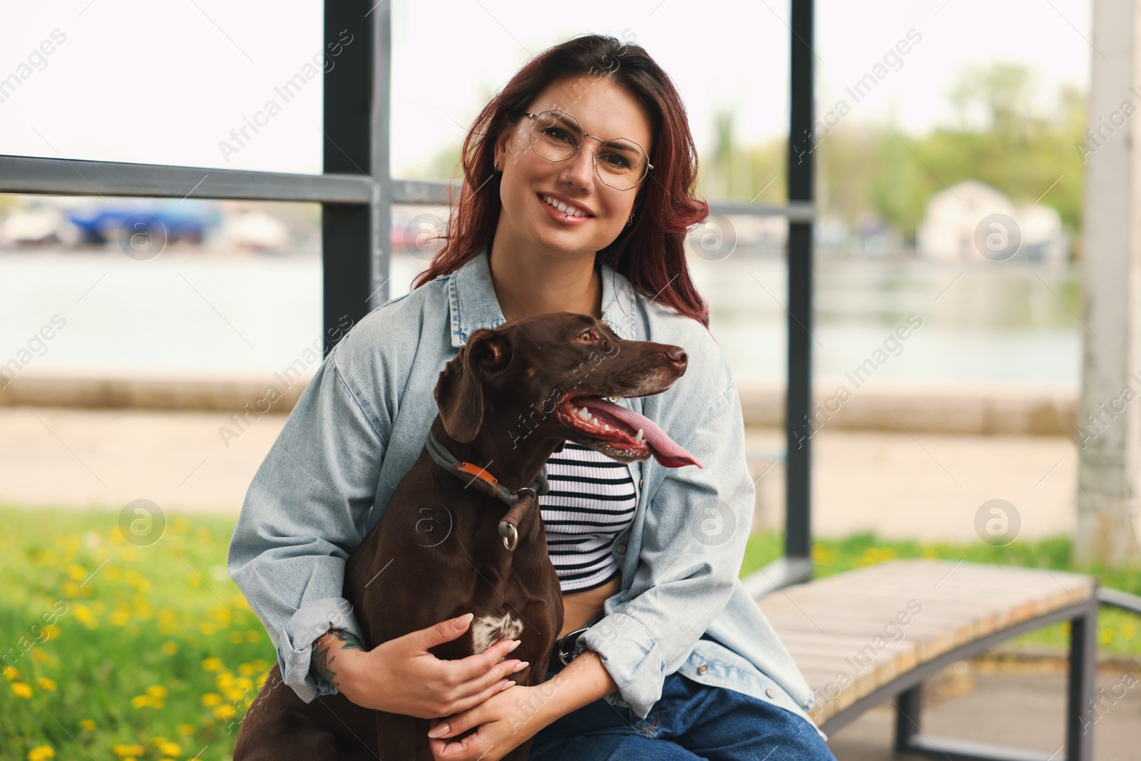 Photo of Woman with her cute German Shorthaired Pointer dog outdoors