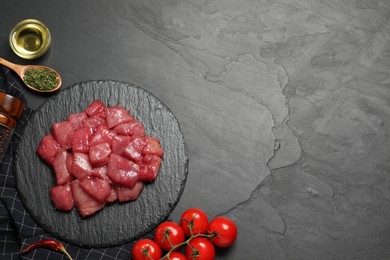 Photo of Raw beef meat and different ingredients for cooking delicious goulash on black table, flat lay. Space for text