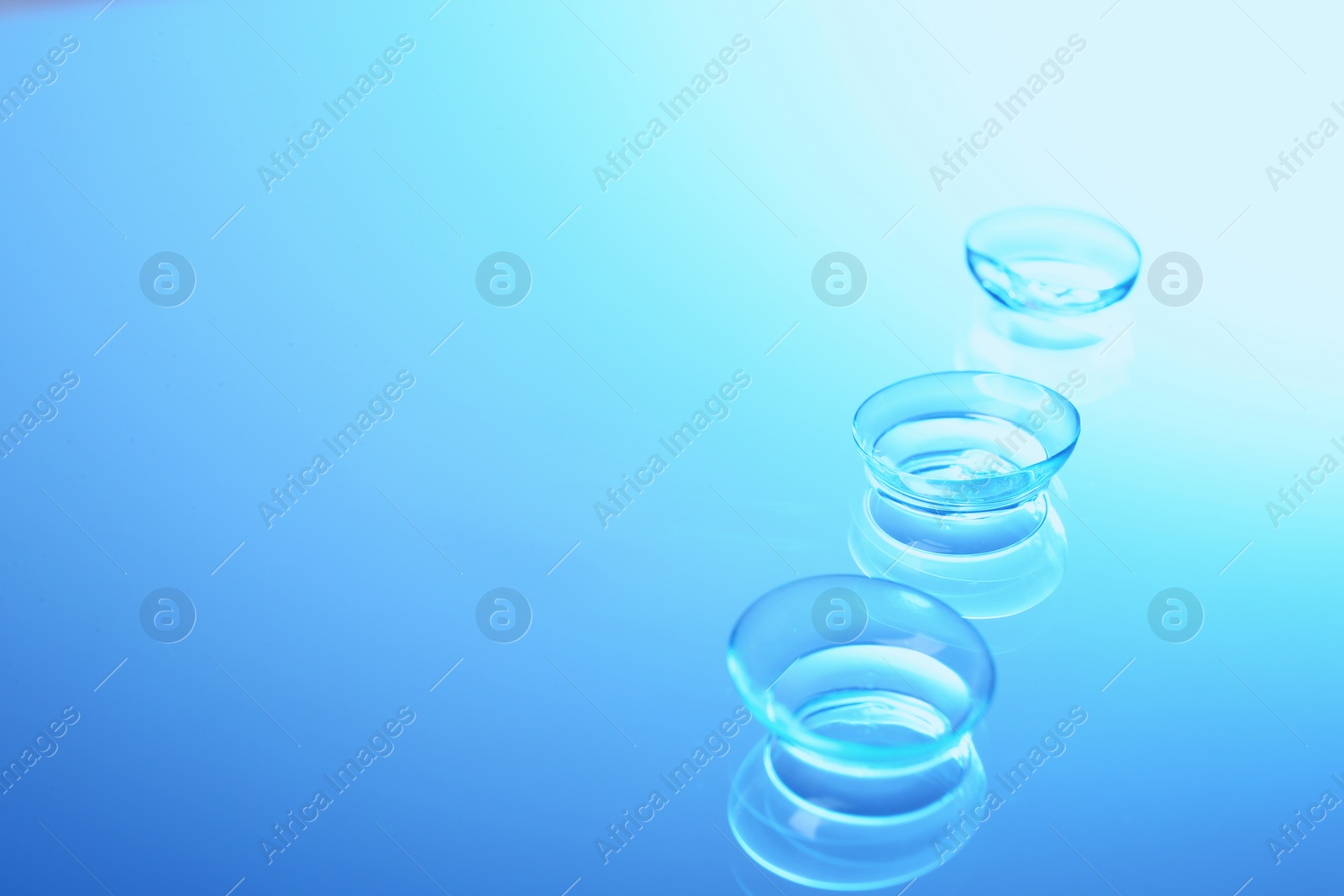 Photo of Contact lenses on color glass background