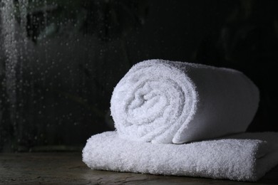 Photo of White terry towels on table in bathroom, space for text