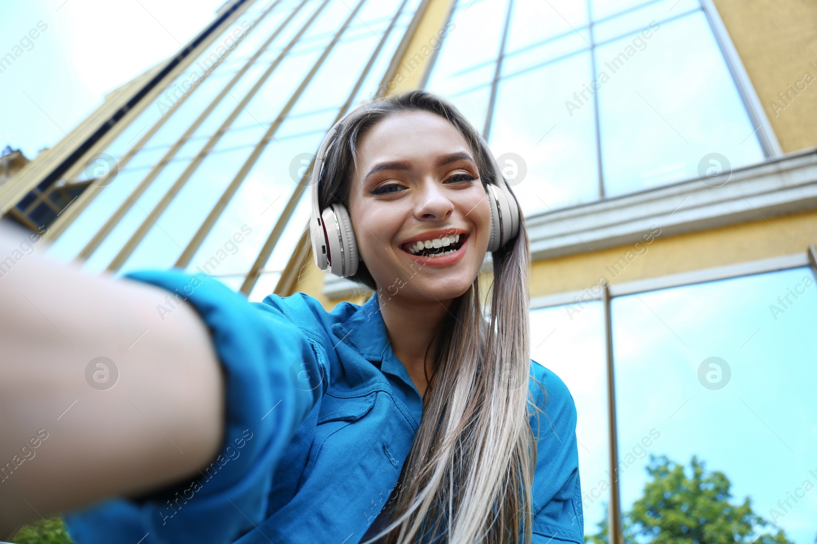 Photo of Happy young woman taking selfie on city street