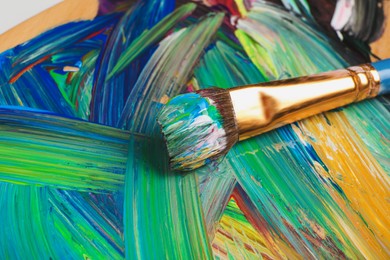 Photo of Abstract colorful acrylic paint and brush, closeup view