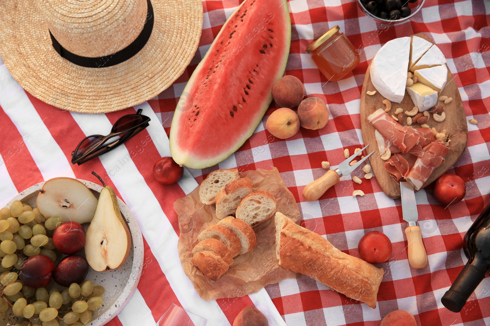 Photo of Different tasty snacks on picnic blanket, flat lay