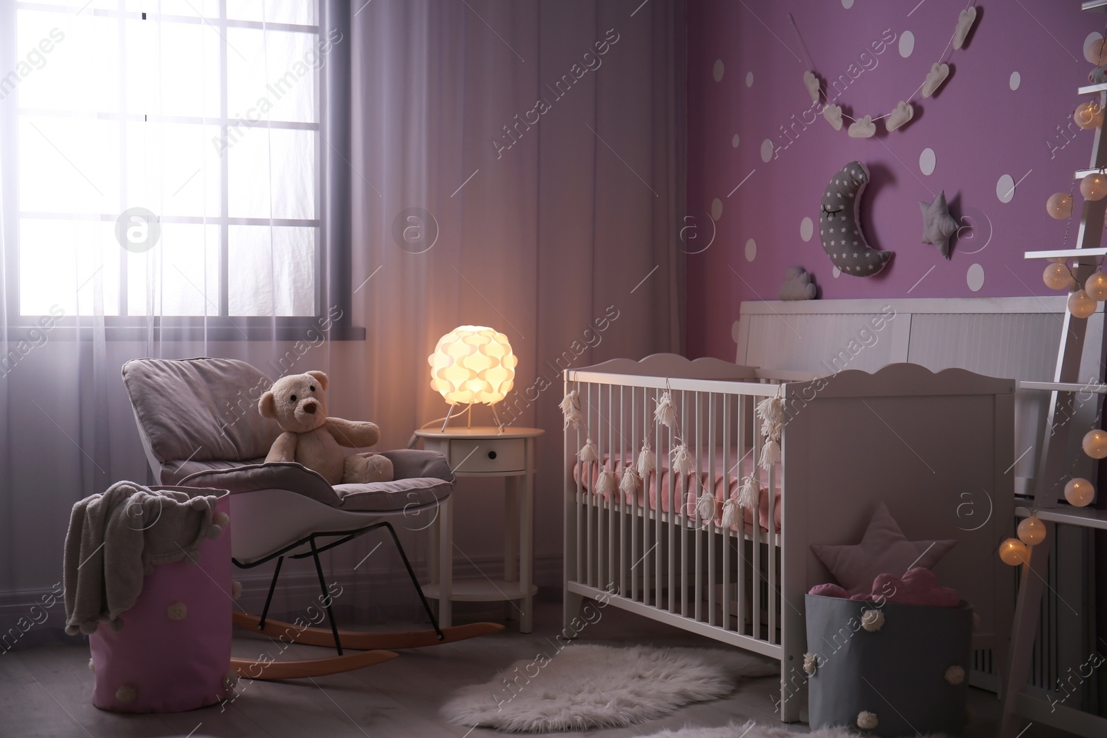 Photo of Baby room interior with crib near color wall